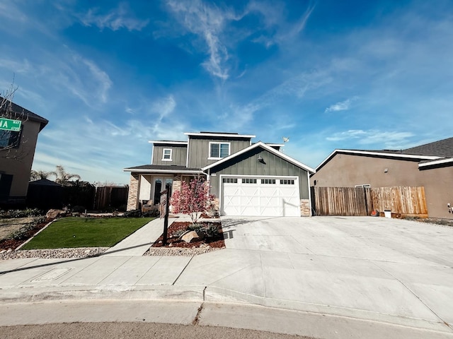 view of front of house with a garage, driveway, board and batten siding, and fence