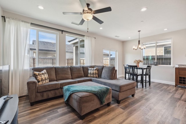 living area with dark wood-style floors, ceiling fan with notable chandelier, baseboards, and recessed lighting