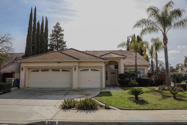 mediterranean / spanish-style home with a garage and a front lawn