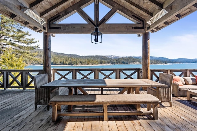 wooden deck with an outdoor living space and a water and mountain view