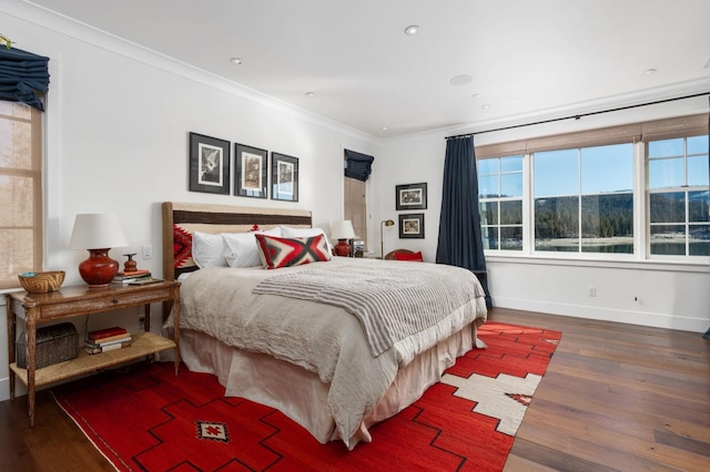 bedroom with hardwood / wood-style flooring, ornamental molding, and a mountain view