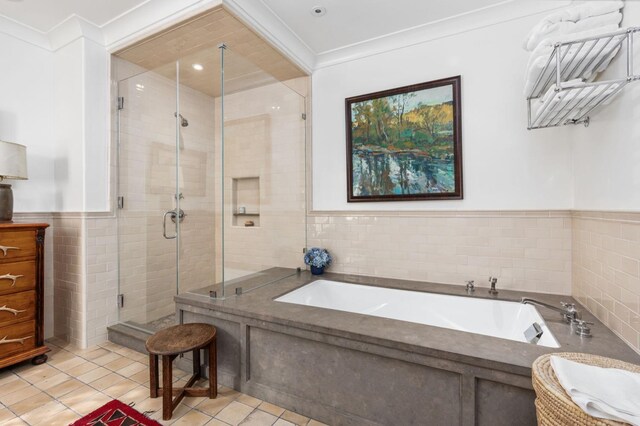 bathroom featuring tile walls, tile patterned floors, ornamental molding, and independent shower and bath