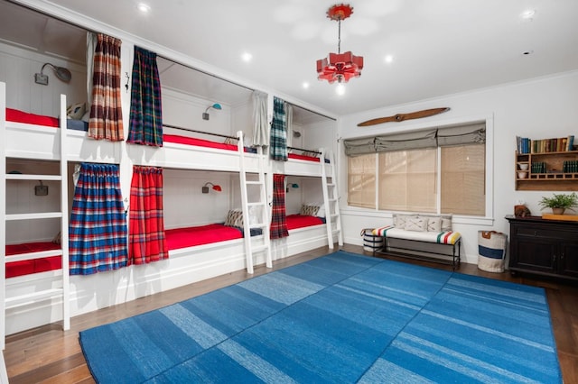 bedroom with ornamental molding, a notable chandelier, and dark hardwood / wood-style flooring
