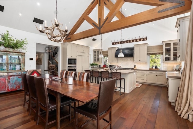 dining area featuring dark wood-type flooring, beamed ceiling, high vaulted ceiling, and a notable chandelier