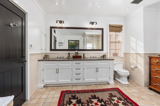 bathroom featuring tile walls, vanity, toilet, crown molding, and tile patterned floors