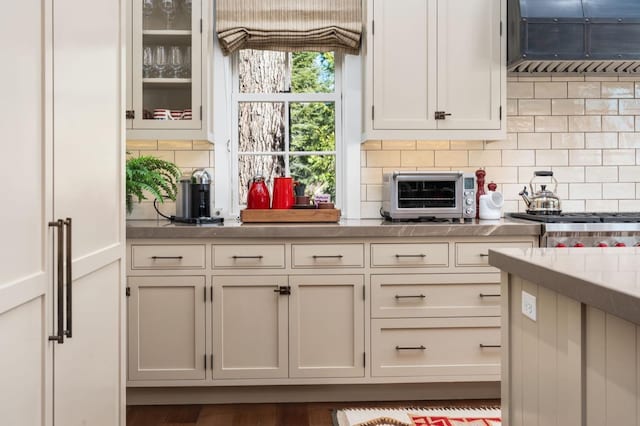 kitchen featuring tasteful backsplash and white cabinetry