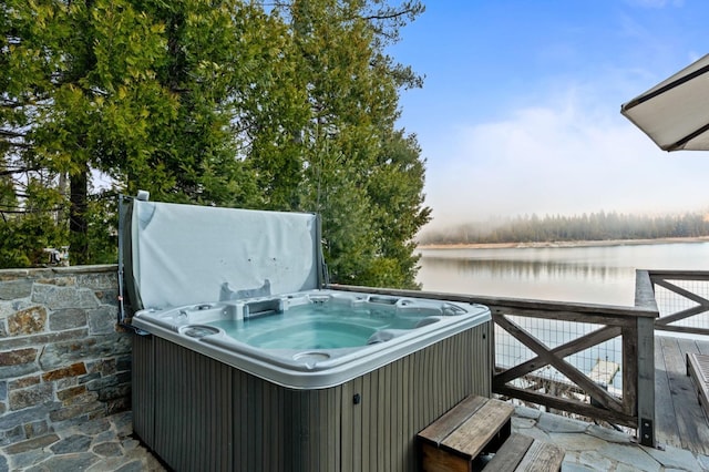 exterior space with a hot tub and a water view