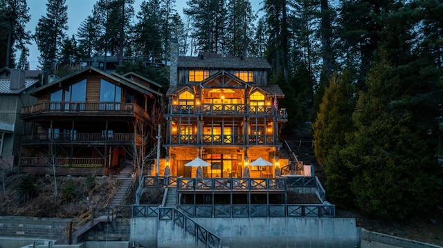 back house at dusk featuring a balcony