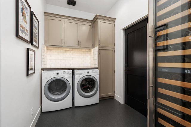 laundry room with wine cooler, cabinets, and washer and dryer