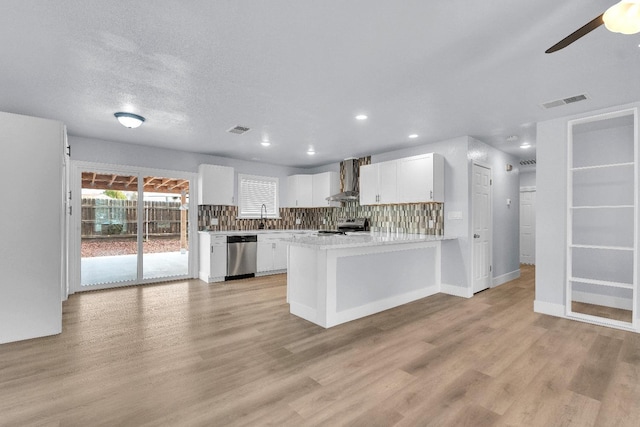 kitchen with white cabinetry, light hardwood / wood-style flooring, appliances with stainless steel finishes, kitchen peninsula, and wall chimney range hood