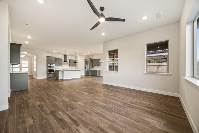 unfurnished living room with ceiling fan and dark hardwood / wood-style flooring