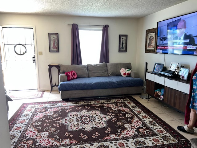 living room with a textured ceiling and light tile patterned flooring