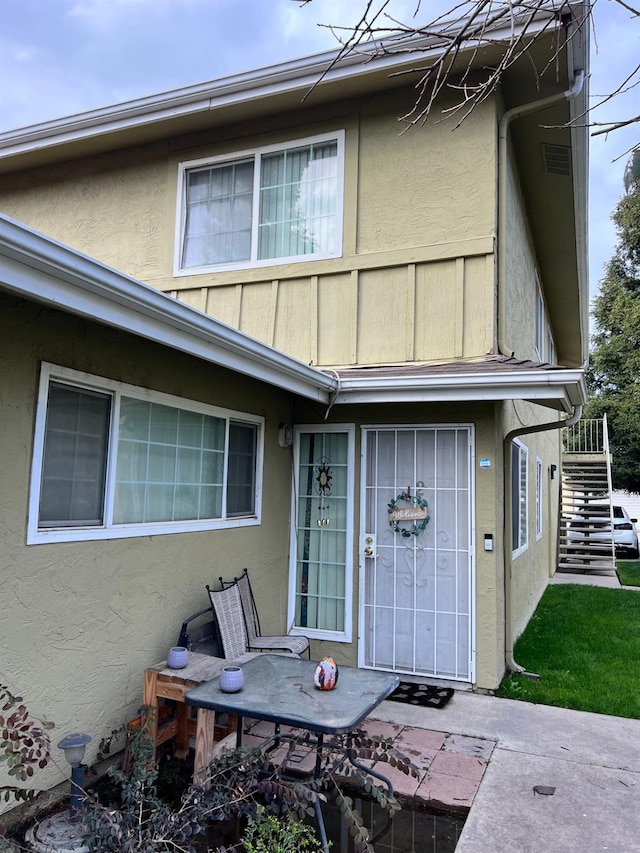 view of exterior entry featuring a patio and stucco siding