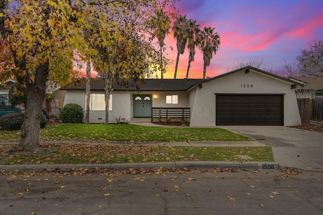 ranch-style home with a garage and a yard