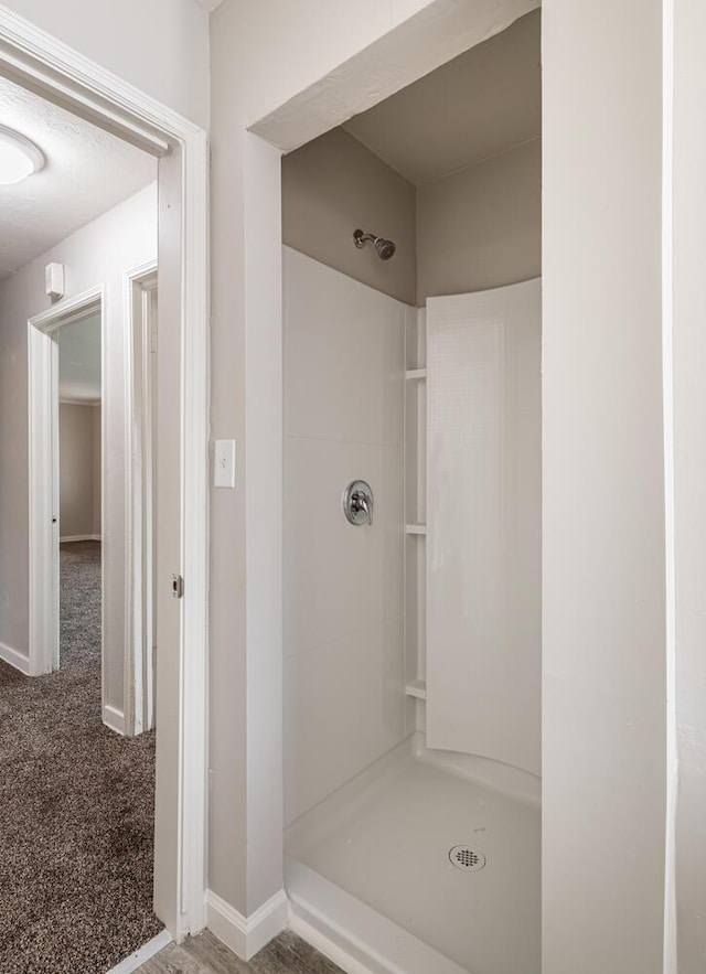 full bath with baseboards and a stall shower