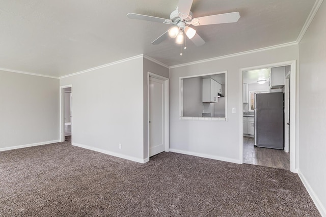 interior space with ceiling fan, ornamental molding, and dark carpet