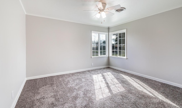 spare room featuring crown molding, a ceiling fan, visible vents, carpet floors, and baseboards