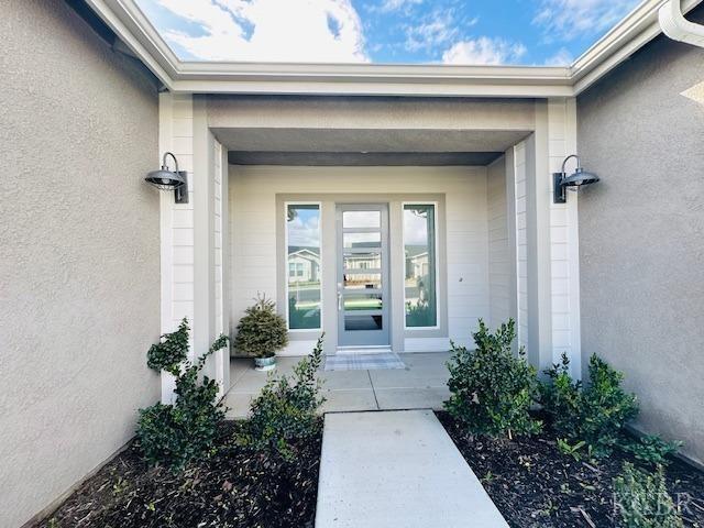 entrance to property featuring stucco siding