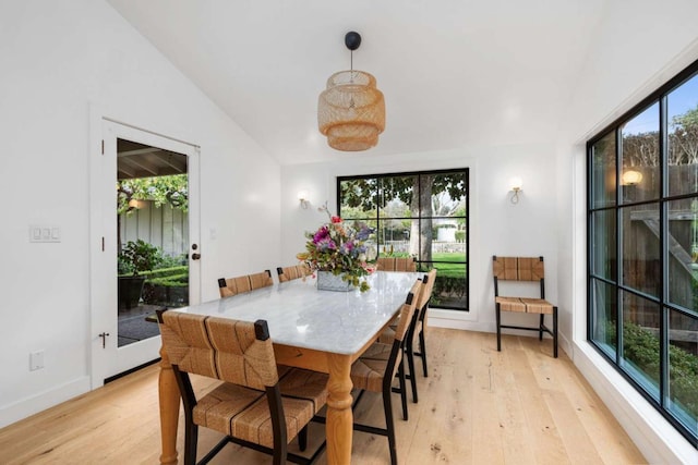 dining space with lofted ceiling and light hardwood / wood-style flooring