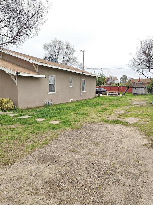 exterior space with a lawn and stucco siding