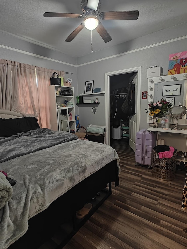 bedroom featuring a closet, a walk in closet, dark wood-style flooring, and a textured ceiling