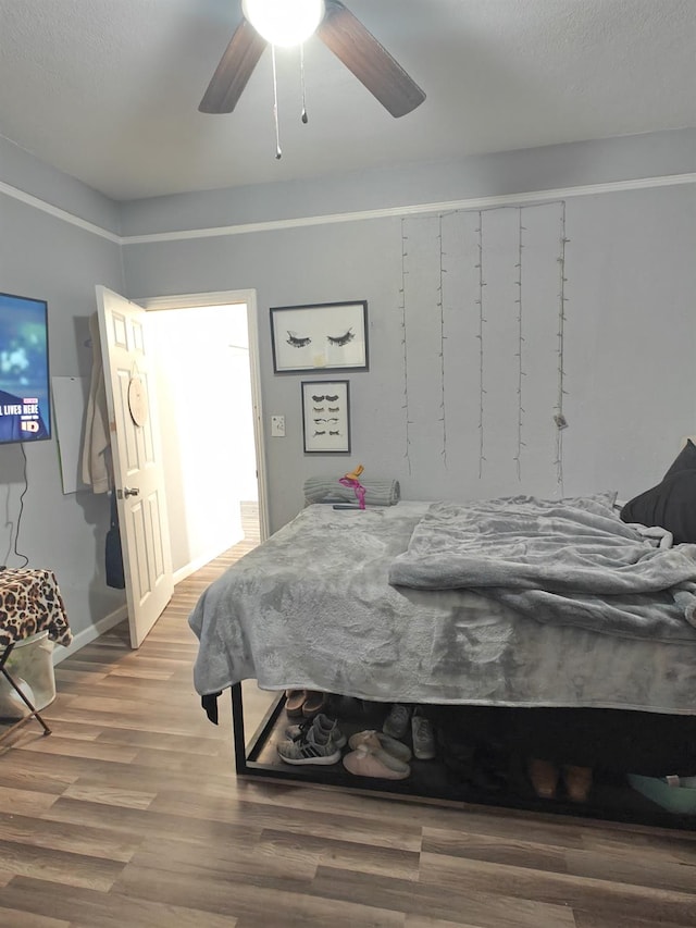 bedroom featuring baseboards, a ceiling fan, and wood finished floors