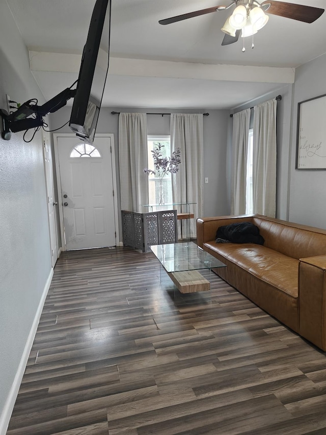 unfurnished living room with dark wood-style flooring, ceiling fan, and baseboards