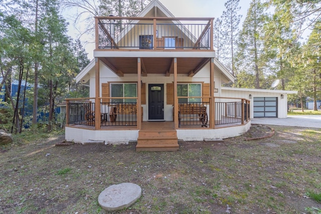 view of front of house featuring cooling unit, a garage, and covered porch