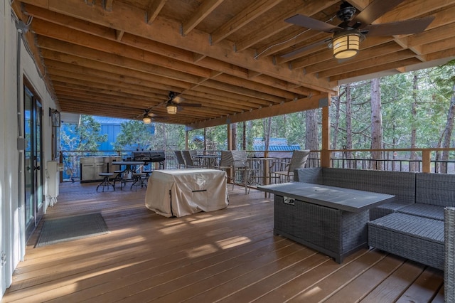 wooden terrace featuring a ceiling fan, outdoor dining space, outdoor lounge area, and a bar