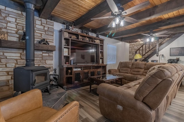 living area with wooden ceiling, ceiling fan, stairway, wood finished floors, and a wood stove