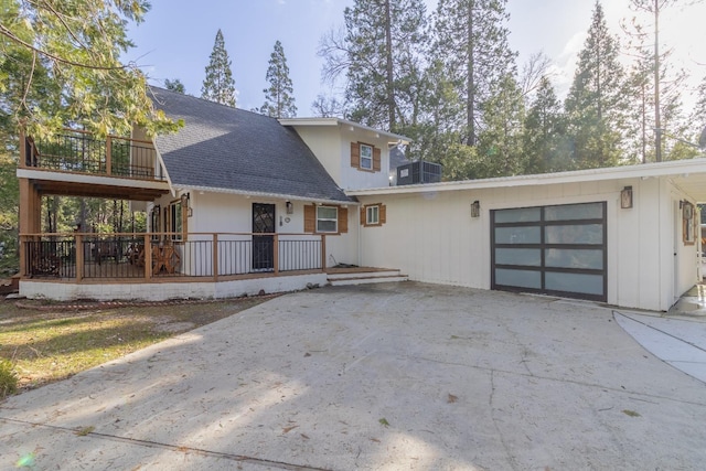 view of front of property with a garage, driveway, and roof with shingles