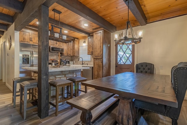 dining area with a chandelier, beamed ceiling, dark wood-style flooring, and wooden ceiling