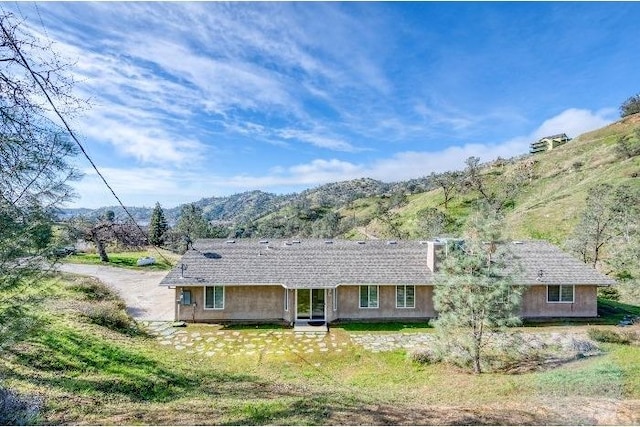 single story home featuring a mountain view and a front yard