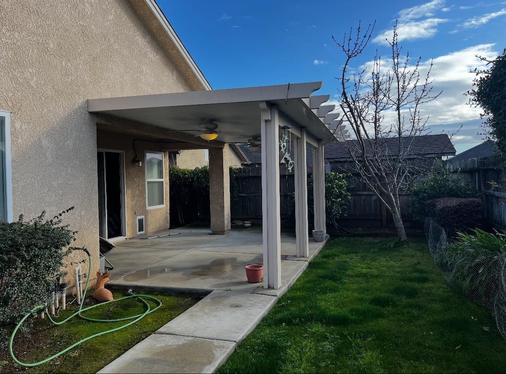 view of yard with ceiling fan and a patio area