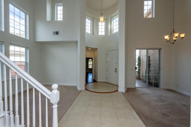 entryway featuring light carpet and a notable chandelier