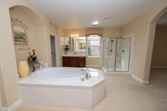 bathroom featuring vanity and independent shower and bath