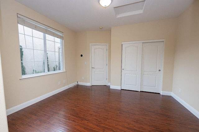 unfurnished bedroom featuring a closet and dark hardwood / wood-style floors