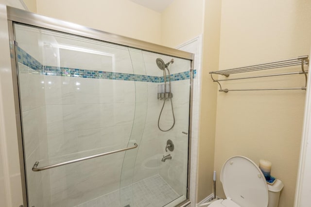 bathroom featuring toilet and an enclosed shower