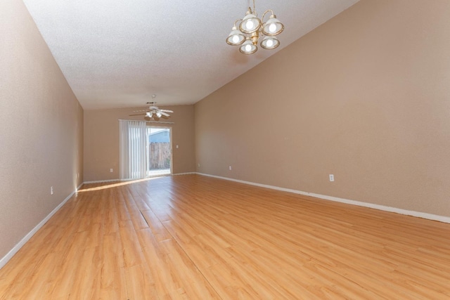 unfurnished room featuring ceiling fan with notable chandelier, vaulted ceiling, light hardwood / wood-style flooring, and a textured ceiling