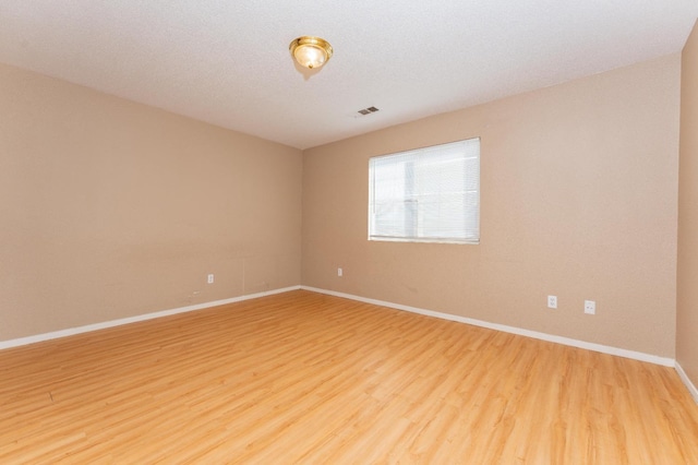 empty room featuring hardwood / wood-style flooring and a textured ceiling