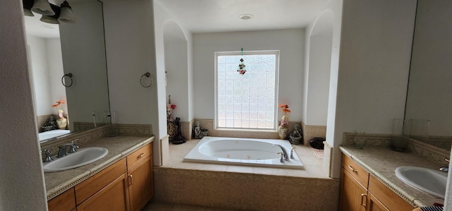 bathroom featuring vanity and tiled tub