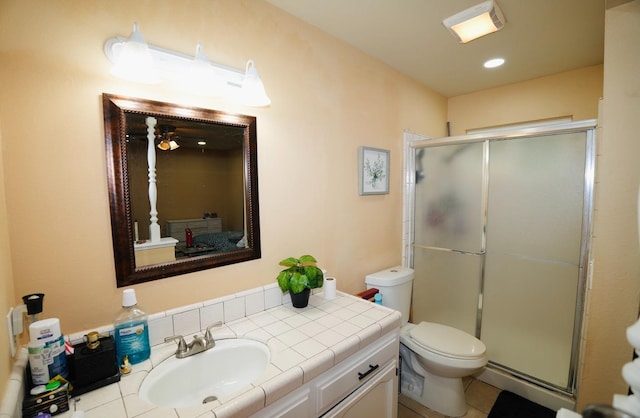 bathroom featuring walk in shower, ceiling fan, vanity, and toilet