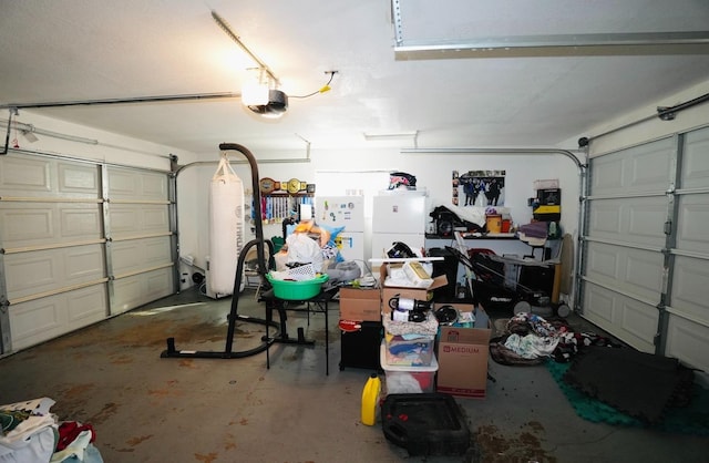 garage with a garage door opener and white fridge