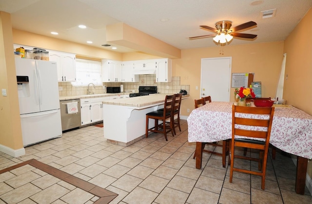 kitchen featuring sink, decorative backsplash, black appliances, and white cabinets