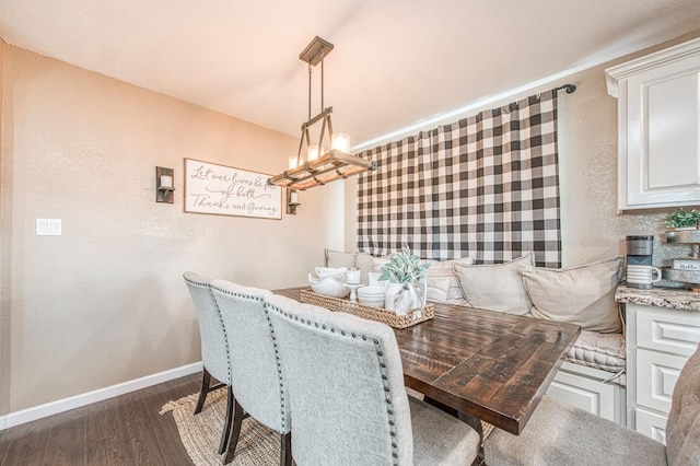 dining space with dark hardwood / wood-style flooring, a notable chandelier, and breakfast area