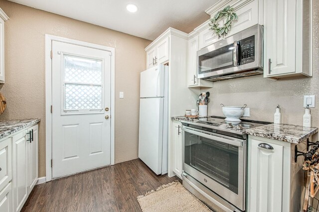 kitchen with light stone countertops, stainless steel appliances, dark hardwood / wood-style floors, and white cabinets