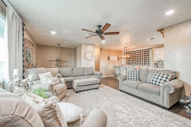 living room with hardwood / wood-style flooring, ceiling fan, and a textured ceiling