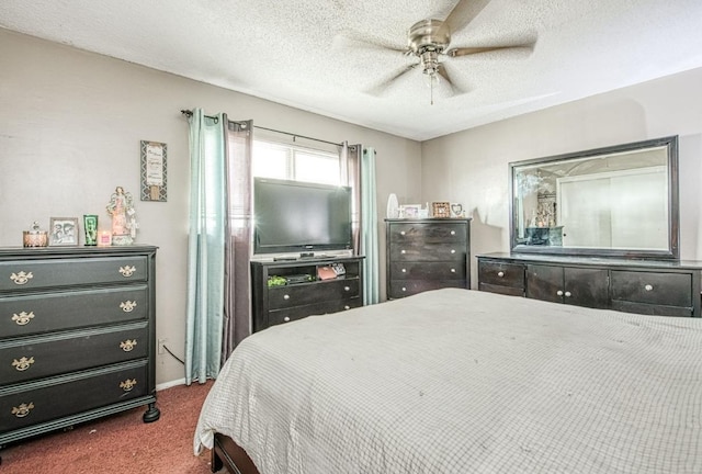 bedroom featuring ceiling fan, a textured ceiling, and dark carpet