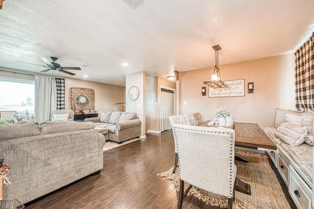 dining area featuring ceiling fan, dark wood-type flooring, and a textured ceiling