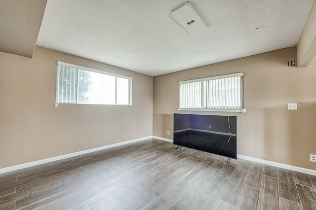 spare room featuring wood-type flooring and a textured ceiling